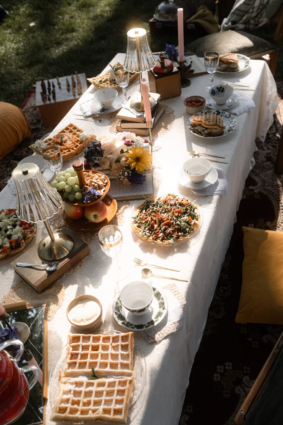 Lange Tafel im Garten mit Waffeln, Kerzen und Sonnenblume - Vintage-Picknick einer alternativen Hochzeit in Halle